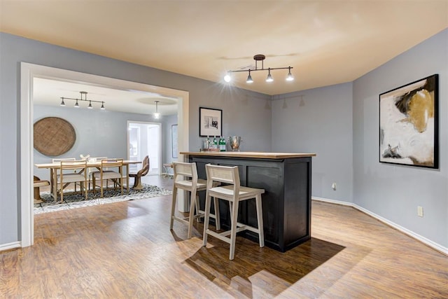 1918 Winding Ridge Rd, Edmond, OK 73034 - indoor dry bar featuring rail lighting and wood finished floors