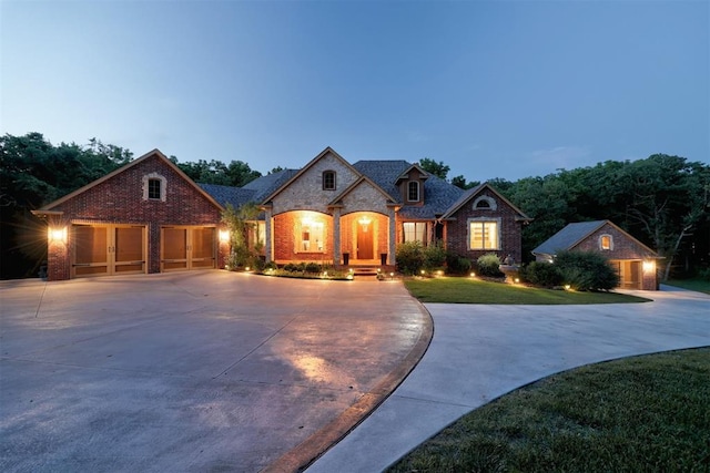 1918 Winding Ridge Rd, Edmond, OK 73034 - french country inspired facade with curved driveway, brick siding, a front yard, and an outbuilding