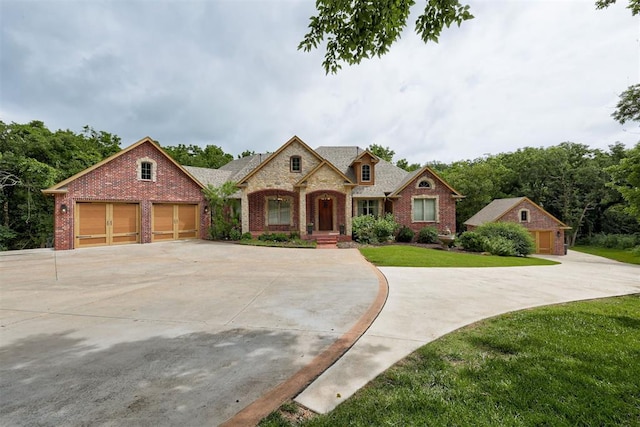 1918 Winding Ridge Rd, Edmond, OK 73034 - french provincial home with brick siding, concrete driveway, a front yard, and a garage