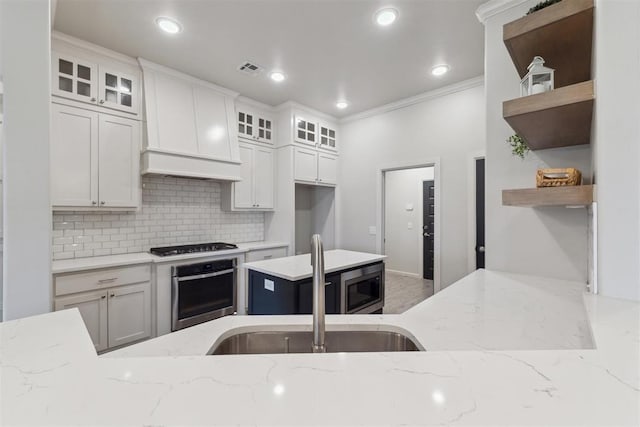 18813 Windy Way Rd, Edmond, OK 73012 - kitchen featuring appliances with stainless steel finishes, open shelves, crown molding, decorative backsplash, and light stone countertops
