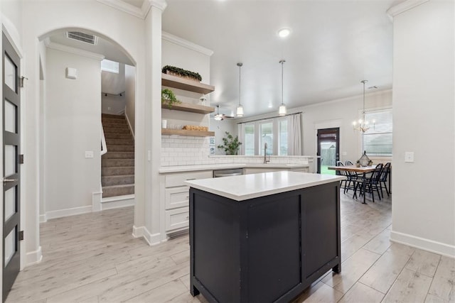 18813 Windy Way Rd, Edmond, OK 73012 - kitchen with open shelves, light countertops, ornamental molding, a kitchen island, and a sink