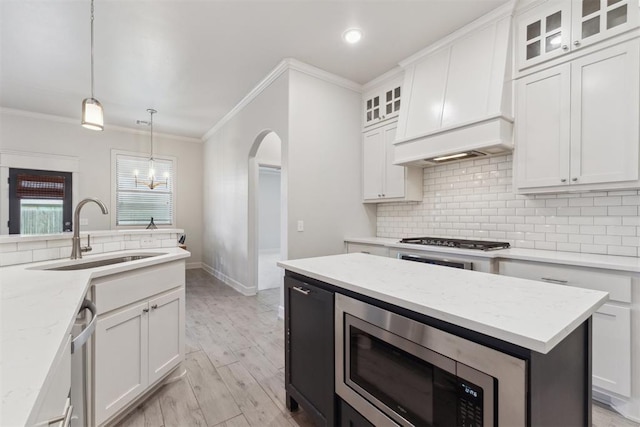 18813 Windy Way Rd, Edmond, OK 73012 - kitchen featuring a sink, appliances with stainless steel finishes, ornamental molding, tasteful backsplash, and white cabinets