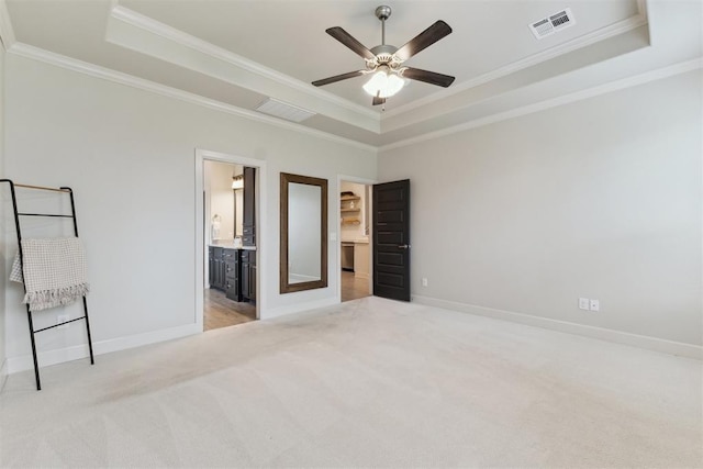 18813 Windy Way Rd, Edmond, OK 73012 - unfurnished bedroom with a tray ceiling, light colored carpet, crown molding, baseboards, and ensuite bath