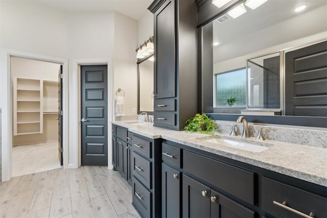 18813 Windy Way Rd, Edmond, OK 73012 - bathroom featuring wood finished floors, double vanity, and a spacious closet