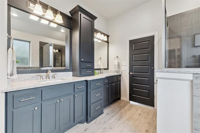 18813 Windy Way Rd, Edmond, OK 73012 - bathroom with tiled shower, double vanity, wood finished floors, and baseboards