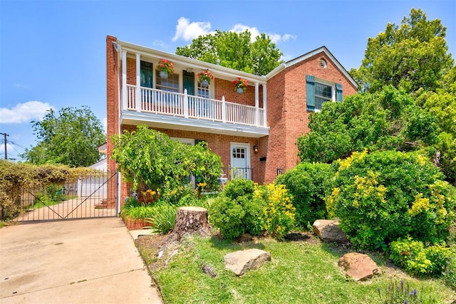 2721 NW 45th St, Oklahoma City, OK 73112 - view of front property with a balcony, brick siding, driveway, and a gate