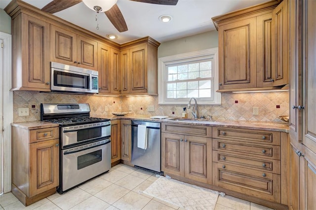2721 NW 45th St, Oklahoma City, OK 73112 - kitchen with stainless steel appliances, light stone countertops, backsplash, light tile patterned floors, and a ceiling fan