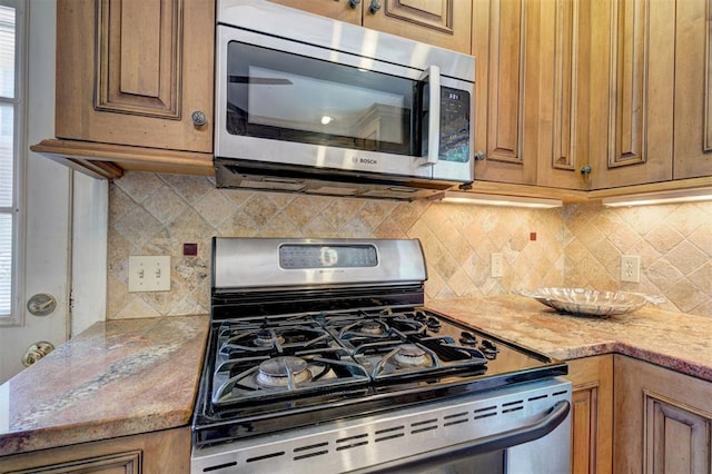 2721 NW 45th St, Oklahoma City, OK 73112 - kitchen featuring stainless steel appliances, backsplash, and brown cabinetry