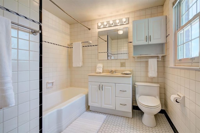 2721 NW 45th St, Oklahoma City, OK 73112 - full bathroom with healthy amount of natural light, vanity, shower / bathtub combination, tile walls, and tile patterned flooring