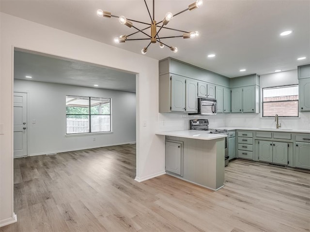 4709 Wilcox Ln, Yukon, OK 73099 - kitchen featuring stainless steel appliances, light countertops, a peninsula, light wood-type flooring, and recessed lighting