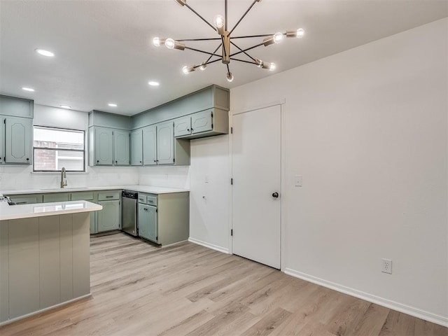 4709 Wilcox Ln, Yukon, OK 73099 - kitchen with a sink, light wood finished floors, light countertops, a peninsula, and a chandelier