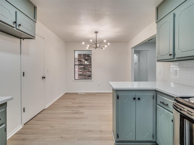 4709 Wilcox Ln, Yukon, OK 73099 - kitchen with a peninsula, a chandelier, light wood finished floors, tasteful backsplash, and light countertops