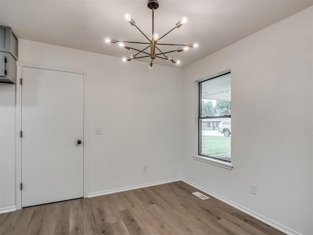 4709 Wilcox Ln, Yukon, OK 73099 - empty room with wood finished floors, a chandelier, and baseboards