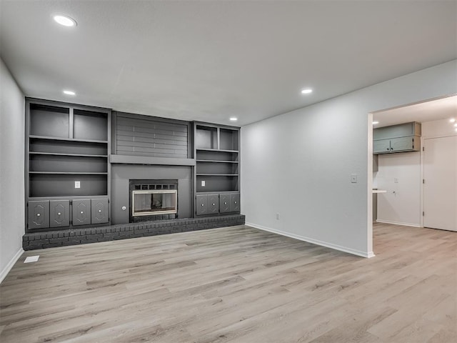4709 Wilcox Ln, Yukon, OK 73099 - unfurnished living room featuring light wood finished floors, baseboards, recessed lighting, a brick fireplace, and built in features