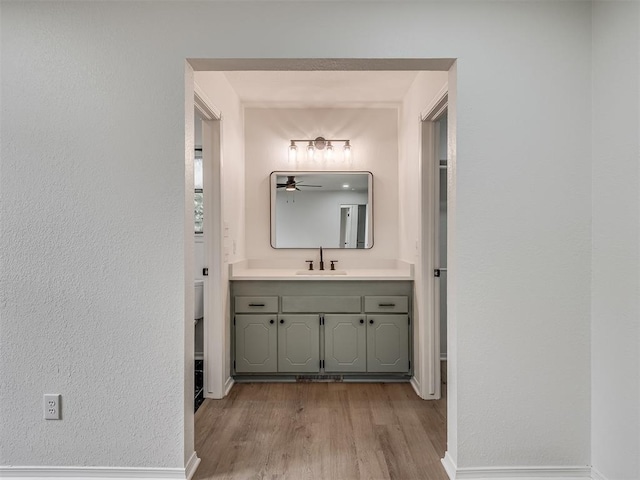 4709 Wilcox Ln, Yukon, OK 73099 - bathroom featuring wood finished floors, vanity, baseboards, and ceiling fan