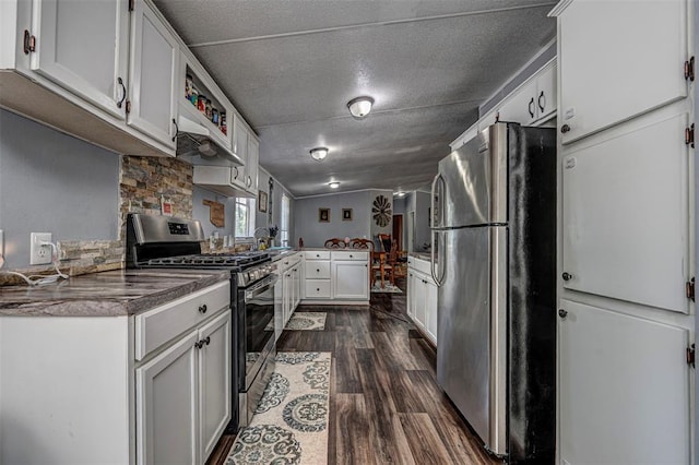 13903 Pleasant Ridge Rd, Jones, OK 73049 - kitchen featuring appliances with stainless steel finishes, dark wood-type flooring, white cabinets, a peninsula, and dark countertops