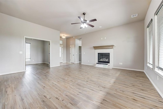 7720 Hawk Ln, Guthrie, OK 73044 - unfurnished living room with a ceiling fan, light wood-style floors, a fireplace with flush hearth, and baseboards