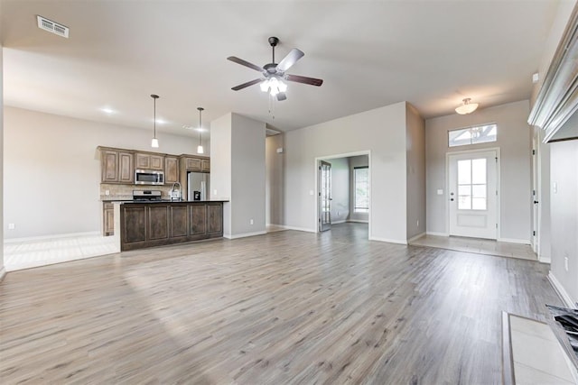 7720 Hawk Ln, Guthrie, OK 73044 - unfurnished living room with light wood-style floors, ceiling fan, and baseboards
