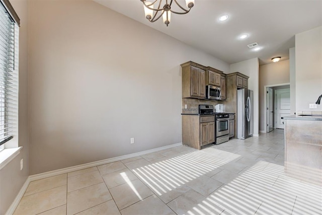 7720 Hawk Ln, Guthrie, OK 73044 - kitchen featuring appliances with stainless steel finishes, a sink, a chandelier, decorative backsplash, and light tile patterned floors