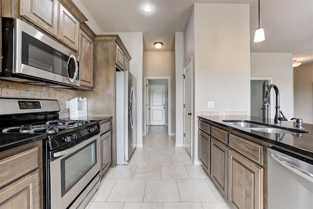 7720 Hawk Ln, Guthrie, OK 73044 - kitchen with appliances with stainless steel finishes, a sink, decorative backsplash, dark stone countertops, and light tile patterned flooring
