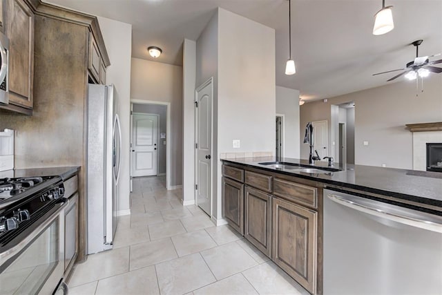 7720 Hawk Ln, Guthrie, OK 73044 - kitchen with stainless steel appliances, a sink, ceiling fan, light tile patterned floors, and decorative light fixtures