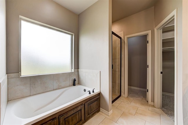 7720 Hawk Ln, Guthrie, OK 73044 - full bathroom with a shower stall, a garden tub, a walk in closet, and tile patterned floors
