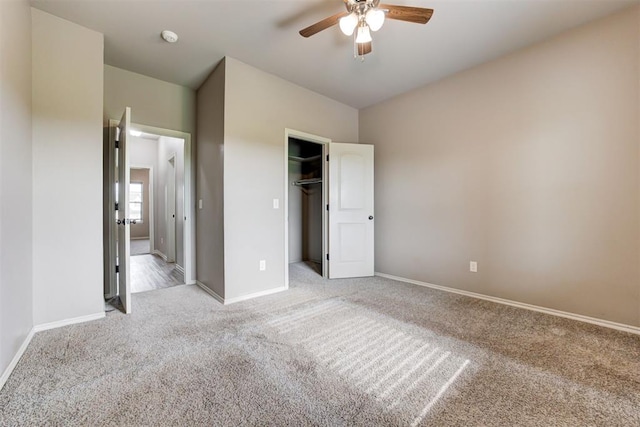 7720 Hawk Ln, Guthrie, OK 73044 - unfurnished bedroom featuring light colored carpet, baseboards, a closet, a ceiling fan, and a walk in closet