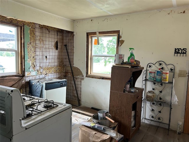 1714 N New York Ave, Mangum, OK 73554 - kitchen with white gas stove, healthy amount of natural light, and wood finished floors