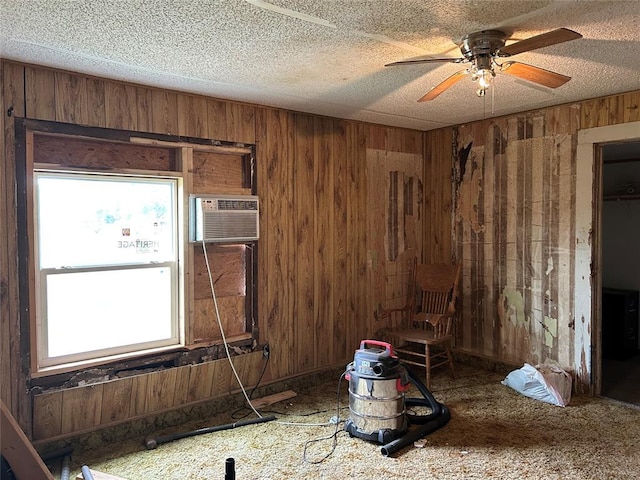 1714 N New York Ave, Mangum, OK 73554 - spare room with wooden walls, a wall unit AC, a ceiling fan, and a textured ceiling