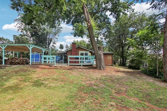 21306 E 10th St, Hinton, OK 73047 - view of grassy yard featuring an outdoor structure, a wooden deck, a carport, and exterior structure