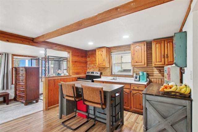 21306 E 10th St, Hinton, OK 73047 - kitchen with stainless steel electric stove, light wood-type flooring, beam ceiling, light countertops, and a kitchen island
