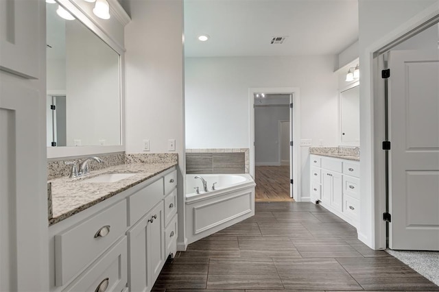 1108 Samantha Ln, Oklahoma City, OK 73160 - bathroom featuring two vanities, a garden tub, and recessed lighting