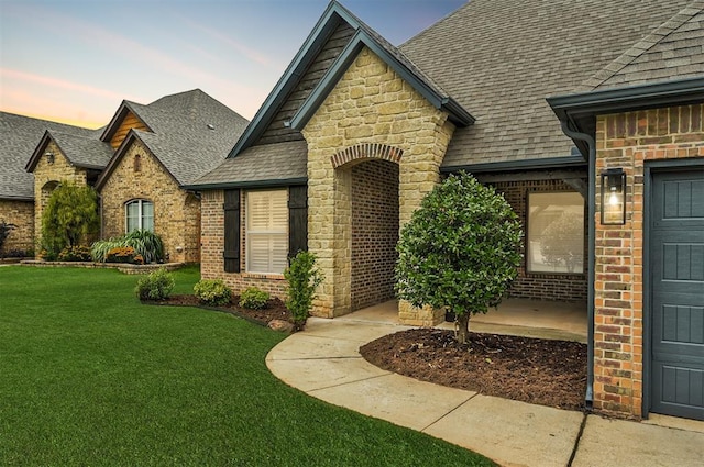 1108 Samantha Ln, Oklahoma City, OK 73160 - view of front of property with a shingled roof, brick siding, a lawn, and stone siding