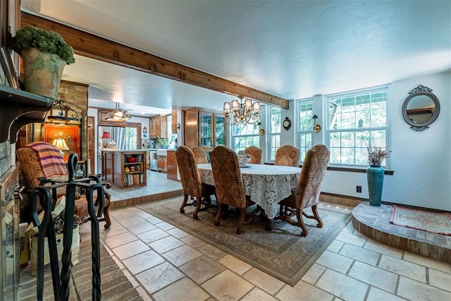 3824 Smoking Oaks Dr, Oklahoma City, OK 73150 - dining room featuring stone tile floors, healthy amount of natural light, a chandelier, and baseboards