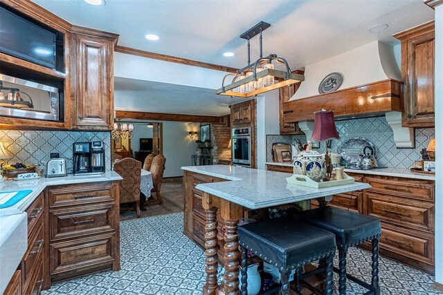 3824 Smoking Oaks Dr, Oklahoma City, OK 73150 - kitchen with stainless steel oven, tasteful backsplash, a kitchen island, recessed lighting, and light stone countertops