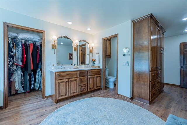 3824 Smoking Oaks Dr, Oklahoma City, OK 73150 - full bathroom featuring baseboards, double vanity, toilet, wood finished floors, and recessed lighting