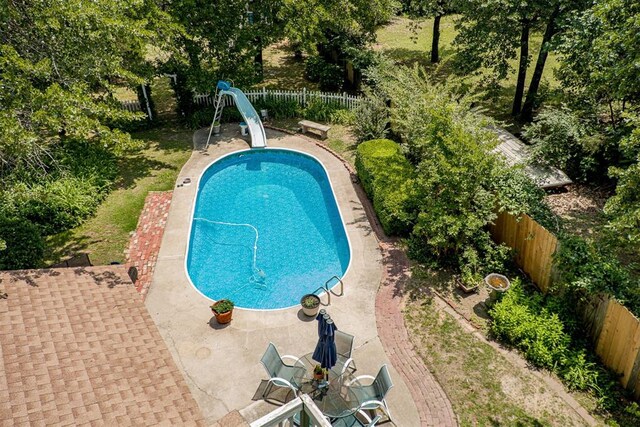 3824 Smoking Oaks Dr, Oklahoma City, OK 73150 - view of swimming pool with a water slide, a fenced backyard, a patio, and view of wooded area