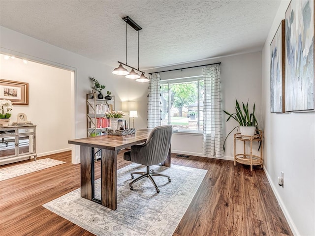 2009 Bella Vista Dr, Edmond, OK 73013 - home office featuring wood finished floors, a textured ceiling, and baseboards