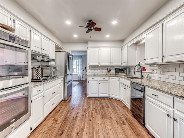 2009 Bella Vista Dr, Edmond, OK 73013 - kitchen featuring black appliances, decorative backsplash, ceiling fan, white cabinets, and recessed lighting