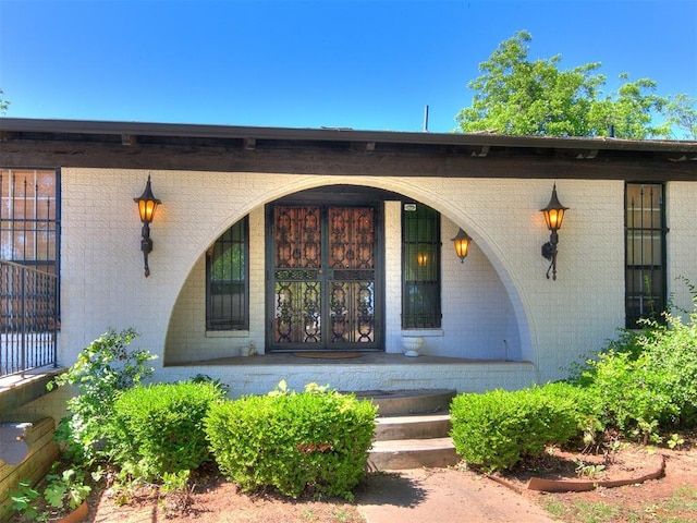 212 W Ridgewood Dr, Midwest City, OK 73130 - doorway to property featuring a porch and brick siding