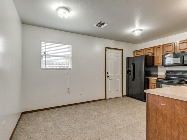 4537 SE 80th St, Del City, OK 73135 - kitchen with black appliances, baseboards, light countertops, and brown cabinets