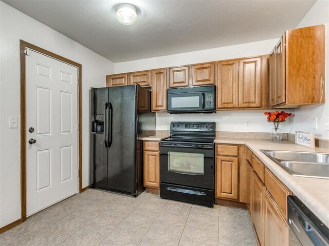 4537 SE 80th St, Del City, OK 73135 - kitchen featuring black appliances, light countertops, brown cabinetry, and light tile patterned floors