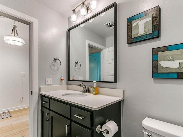 16125 Buffalo Dr, Moore, OK 73170 - bathroom featuring toilet, vanity, wood finished floors, and baseboards