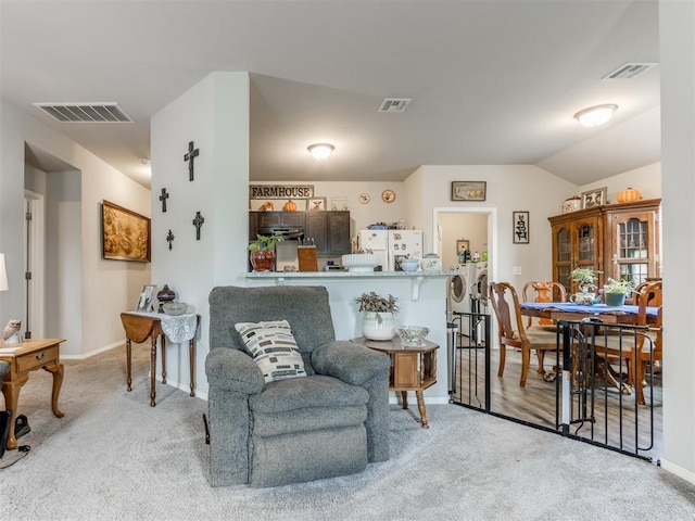 9436 SW 37th St, Oklahoma City, OK 73179 - carpeted living room featuring washing machine and clothes dryer, baseboards, and lofted ceiling