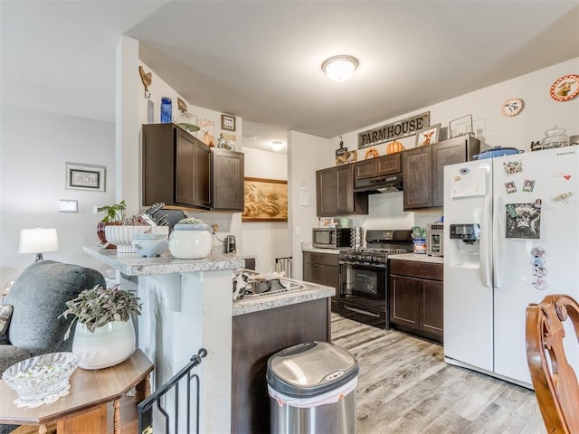 9436 SW 37th St, Oklahoma City, OK 73179 - kitchen featuring white refrigerator with ice dispenser, black range with gas cooktop, stainless steel microwave, dark brown cabinetry, and a peninsula