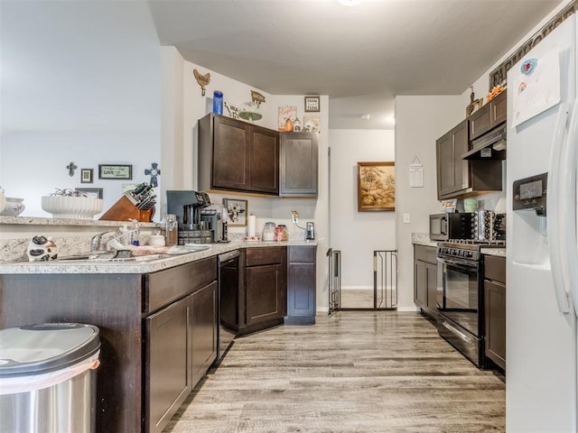 9436 SW 37th St, Oklahoma City, OK 73179 - kitchen featuring black appliances, dark brown cabinets, light wood-style floors, light countertops, and under cabinet range hood