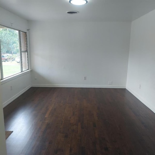 7123 NW 44th St, Bethany, OK 73008 - empty room with dark wood finished floors and baseboards