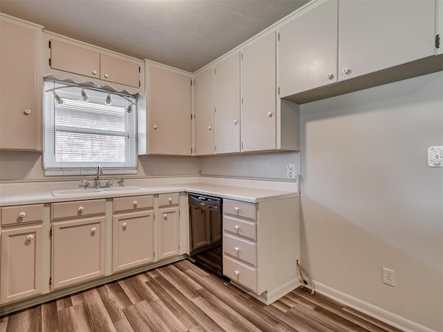 4809 N Pate Ave, Oklahoma City, OK 73112 - kitchen featuring black dishwasher, a sink, light wood-style flooring, light countertops, and baseboards