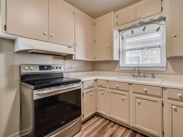 4809 N Pate Ave, Oklahoma City, OK 73112 - kitchen featuring stainless steel range with electric cooktop, under cabinet range hood, a sink, and light countertops