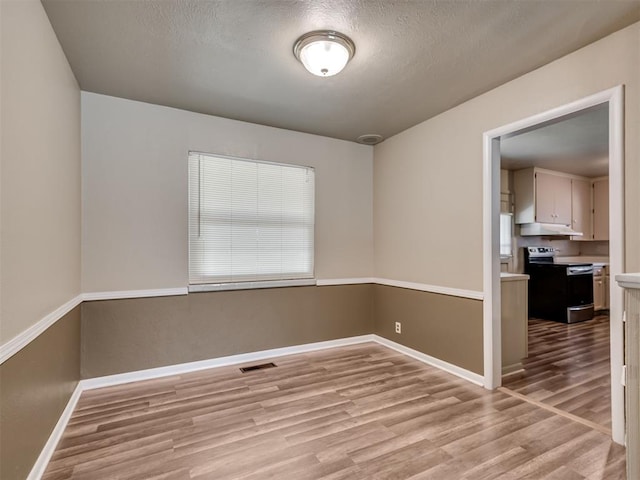4809 N Pate Ave, Oklahoma City, OK 73112 - spare room with wood finished floors, baseboards, and a textured ceiling